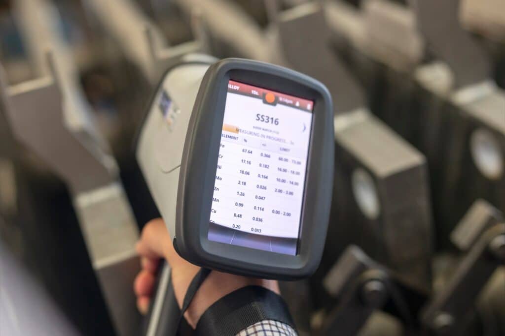 person using an XRF gun to scan materials