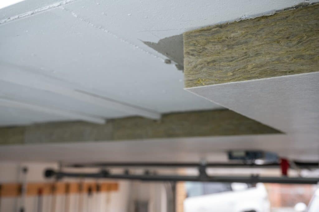 Mineral wool insulation visible in garage ceiling