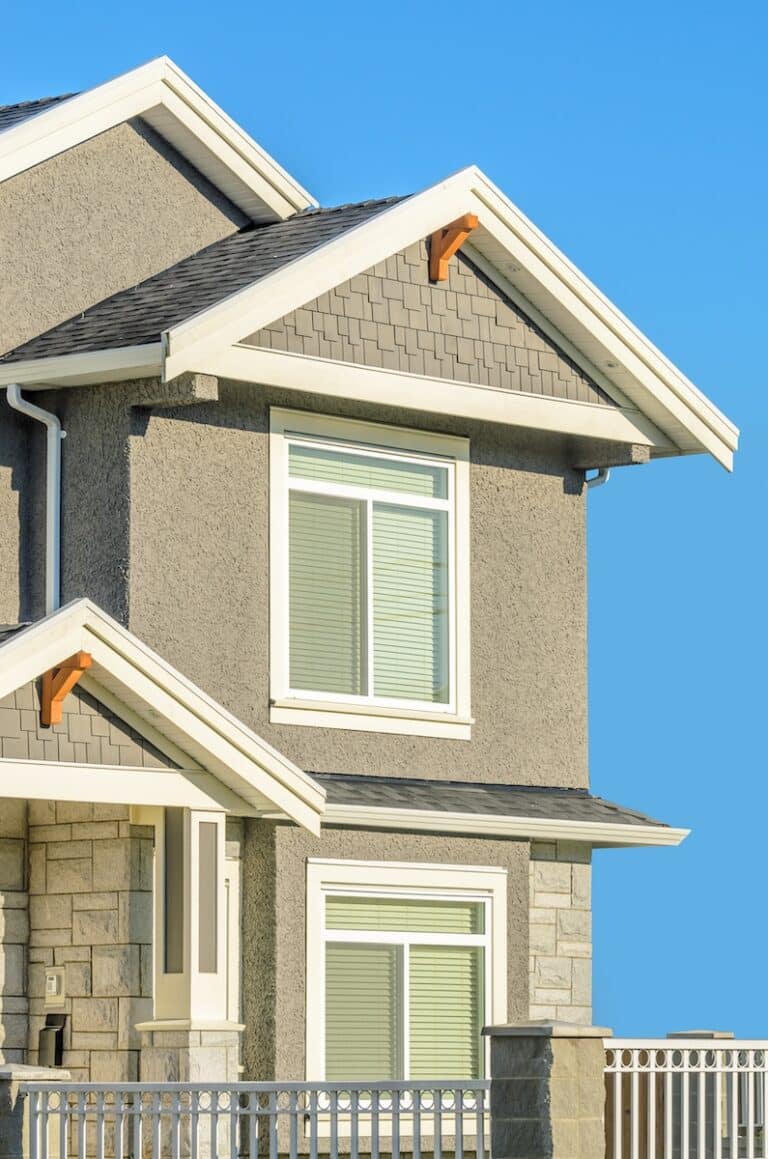 Close-up of a two-story home's roofline, gutters, and windows inspected during a Navarre, FL home inspection