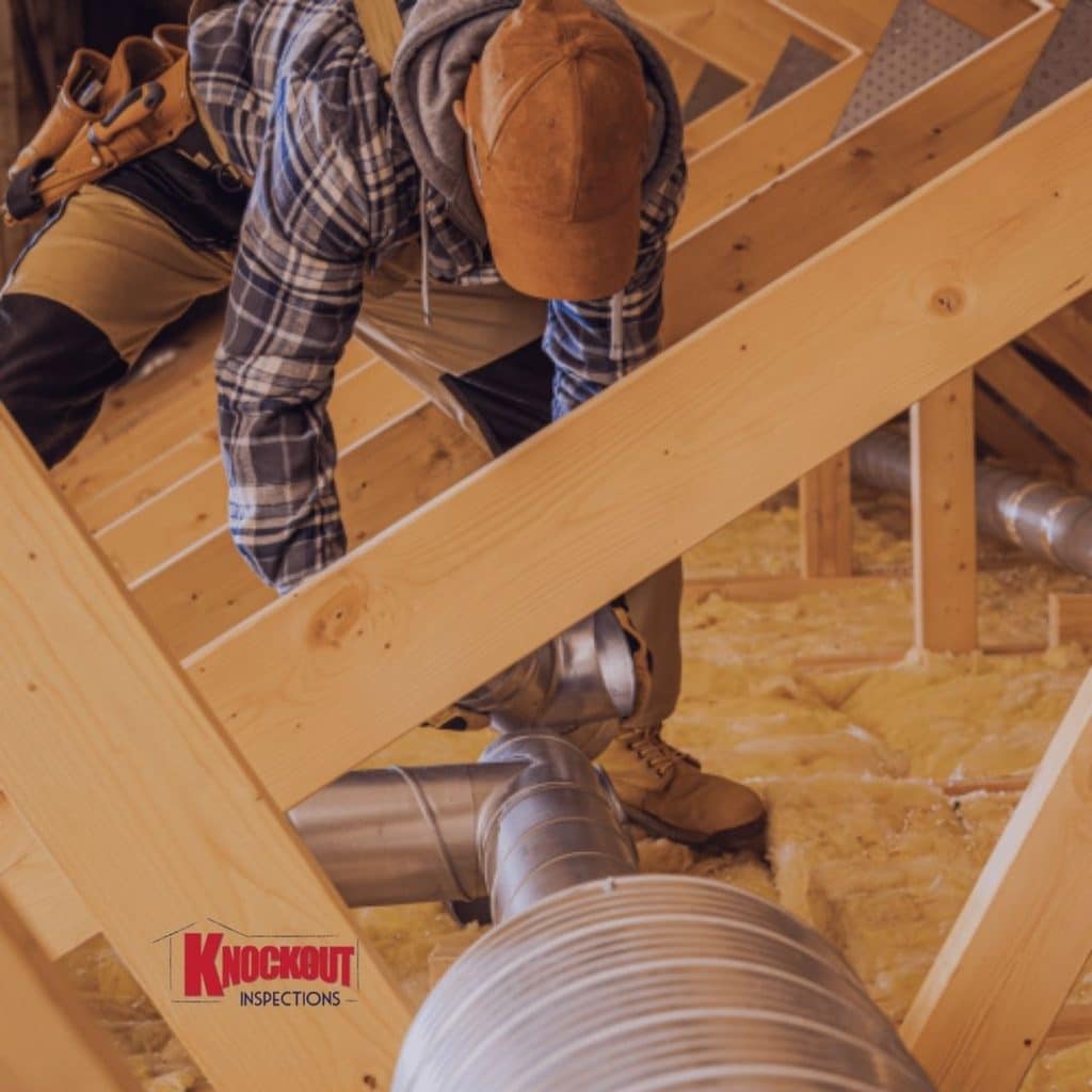 Installer running rigid duct trunk and branch lines through attic framing after a Manual D duct design